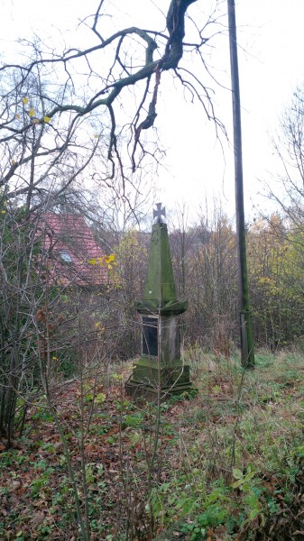 Kleines Denkmal vor der Hergisdorfer Kirche.